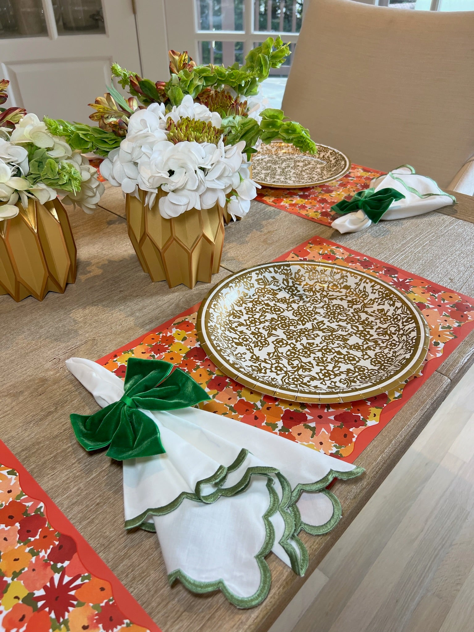 Fall themed tablescape featuring our Fall Florals disposable paper placemats, gold heavy-duty paper plates, green bow napkin rings, and gold paper vase wraps