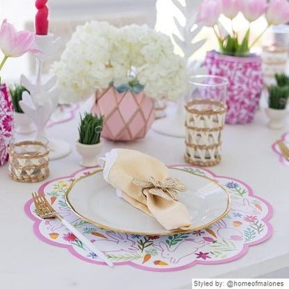 Table setting with bunny scalloped round paper placemats layered with a  gold and white plate and yellow napkin